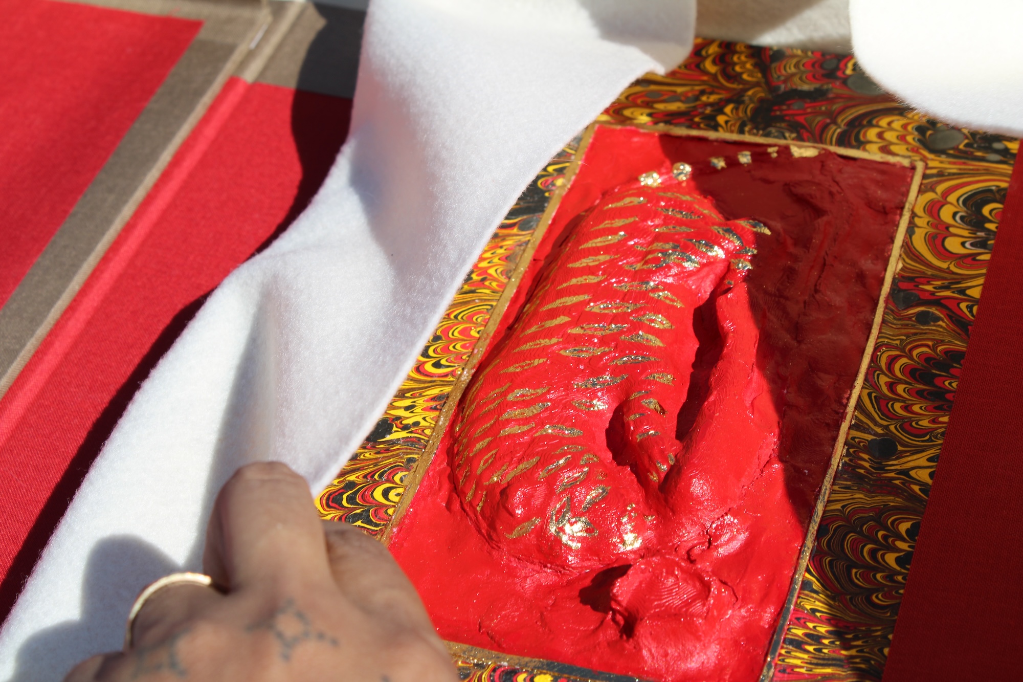 a close up of a hand unwrapping a colorful book from the box