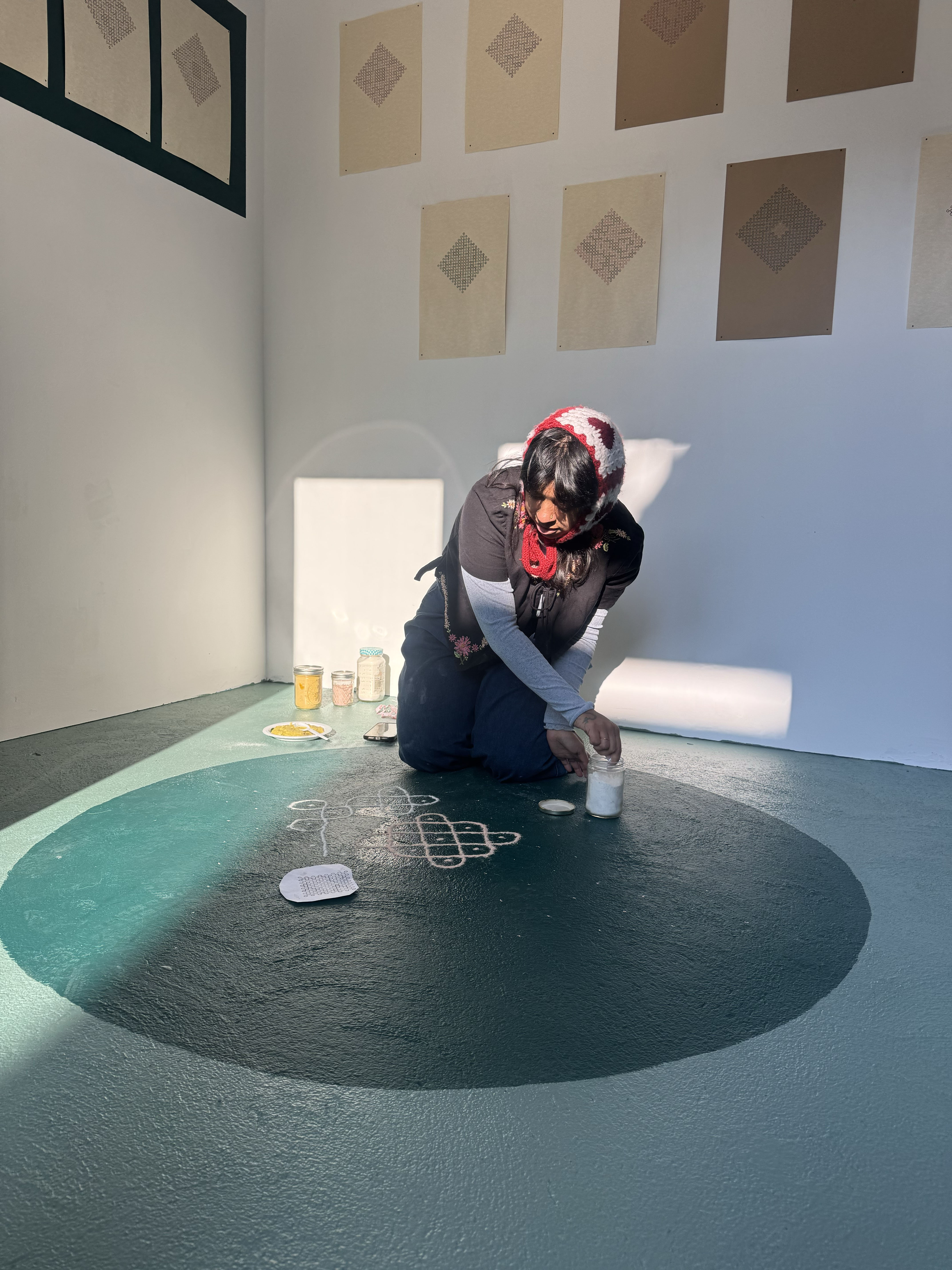 me drawing the kolam on the ground with rice flour.